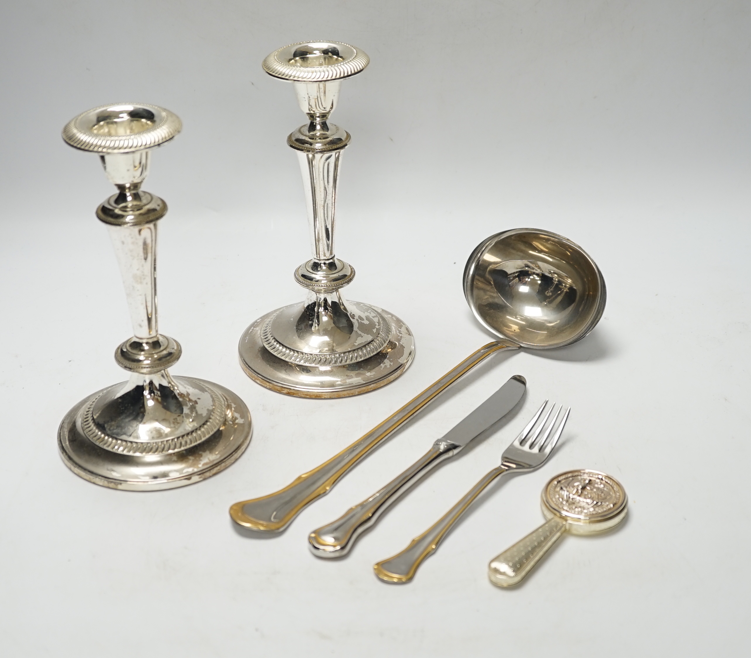 Assorted plated flatware and a pair of plated candlesticks